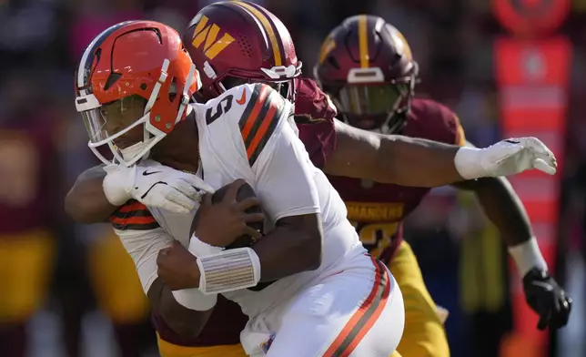 Cleveland Browns quarterback Jameis Winston, front is sacked by Washington Commanders quarterback Jayden Daniels, back, during the second half of an NFL football game in Landover, Md., Sunday, Oct. 6, 2024. (AP Photo/Stephanie Scarbrough)