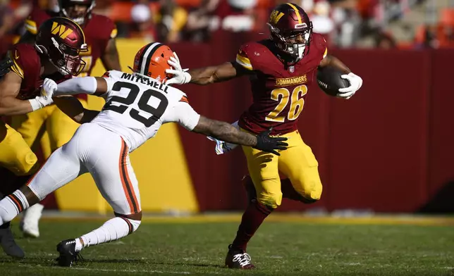 Washington Commanders running back Jeremy McNichols (26) runs past Cleveland Browns cornerback Cameron Mitchell (29) during the second half of an NFL football game in Landover, Md., Sunday, Oct. 6, 2024. (AP Photo/Nick Wass)