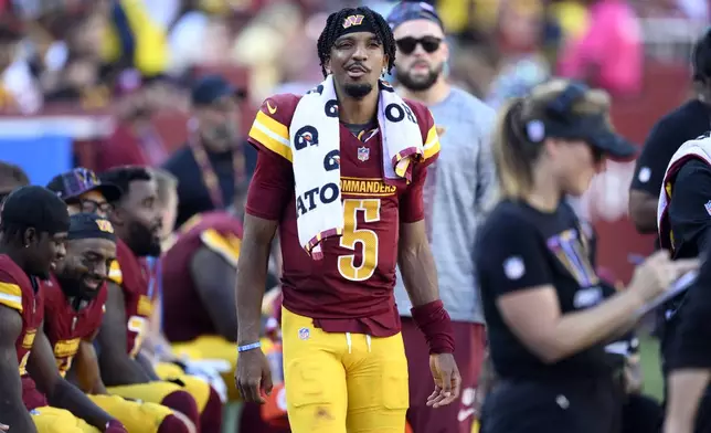 Washington Commanders quarterback Jayden Daniels (5) watches from the sidelines in the fourth quarter against the Cleveland Browns of an NFL football game in Landover, Md., Sunday, Oct. 6, 2024. (AP Photo/Nick Wass)