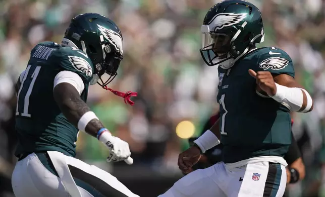 Philadelphia Eagles wide receiver A.J. Brown (11) celebrates his touchdown with Eagles quarterback Jalen Hurts (1) during the first half of an NFL football game against the Cleveland Browns on Sunday, Oct. 13, 2024, in Philadelphia. (AP Photo/Matt Slocum)