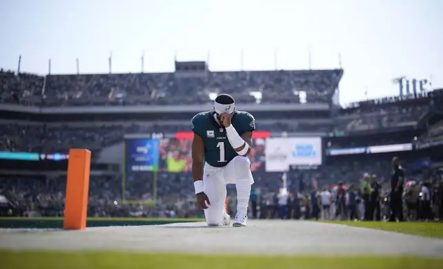 Philadelphia Eagles quarterback Jalen Hurts (1) kneels before an NFL football game against the Cleveland Browns on Sunday, Oct. 13, 2024, in Philadelphia. (AP Photo/Matt Slocum)