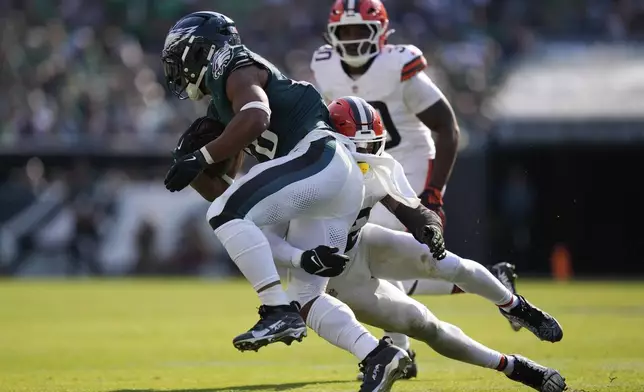 Cleveland Browns safety Rodney McLeod Jr. (12) takes down Philadelphia Eagles running back Saquon Barkley (26) during the second half of an NFL football game Sunday, Oct. 13, 2024, in Philadelphia. (AP Photo/Matt Rourke)