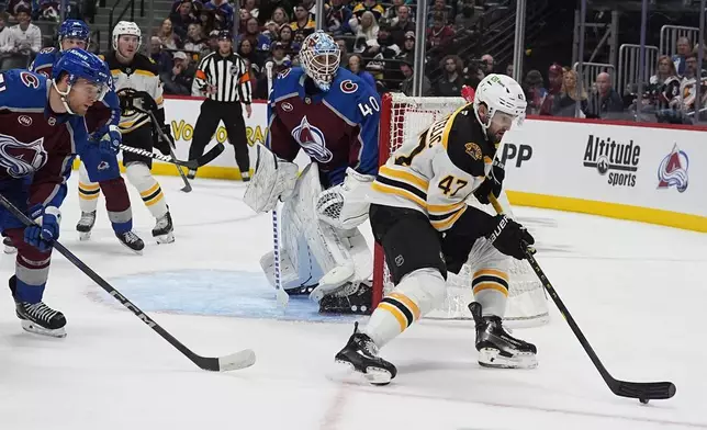 Boston Bruins center Mark Kastelic, right, collects the puck as Colorado Avalanche goaltender Alexandar Georgiev, center, and right wing Nikolai Kovalenko defend in the second period of an NHL hockey game Wednesay, Oct. 16, 2024, in Denver. (AP Photo/David Zalubowski)