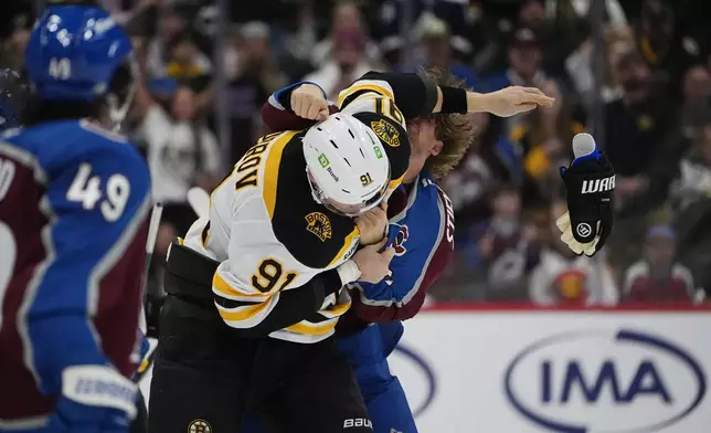 Colorado Avalanche center Matt Stienburg, back, fights with Boston Bruins defenseman Nikita Zadorov in the second period of an NHL hockey game Wednesday, Oct. 16, 2024, in Denver. (AP Photo/David Zalubowski)