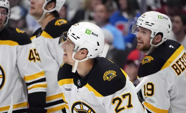 Boston Bruins defenseman Hampus Lindholm , front, celebrates after scoring a goal with teammates in the second period of an NHL hockey game against the Colorado Avalanche Wednesday, Oct. 16, 2024, in Denver. (AP Photo/David Zalubowski)