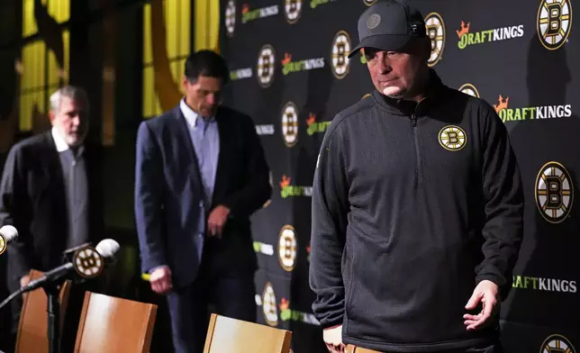 Boston Bruins head coach Jim Montgomery, right, arrives for a media availability with team president Cam Neely, left, and general manager Don Sweeney, Monday, Sept. 30, 2024, in Boston. (AP Photo/Charles Krupa)