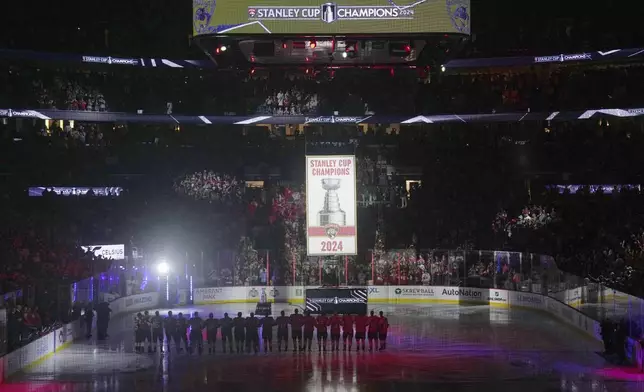 The Florida Panthers raise their Stanley Cup championship banner before the start of the NHL hockey game against the Boston Bruins, Tuesday, Oct. 8, 2024, in Sunrise, Fla. (AP Photo/Jim Rassol)