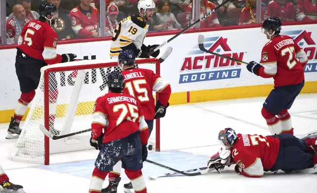 Boston Bruins center John Beecher (19) celebrates a goal by teammate Charlie McAvoy against the Florida Panthers during the second period of an NHL hockey game, Tuesday, Oct. 8, 2024, in Sunrise, Fla. (AP Photo/Jim Rassol)