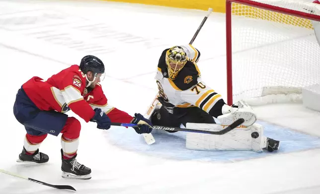 Boston Bruins goaltender Joonas Korpisalo (70) makes a save against Florida Panthers center Aleksander Barkov (16) during the second period of an NHL hockey game, Tuesday, Oct. 8, 2024, in Sunrise, Fla. (AP Photo/Jim Rassol)