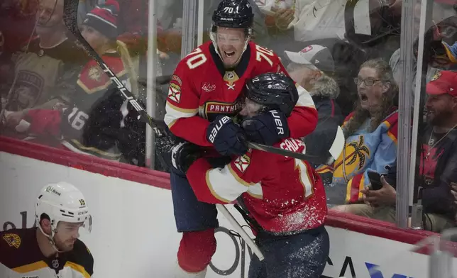 Florida Panthers left wing Jonah Gadjovich (12) celebrates a goal with center Jesper Boqvist (70) against the Boston Bruins during the second period of an NHL hockey game, Tuesday, Oct. 8, 2024, in Sunrise, Fla. (AP Photo/Jim Rassol)