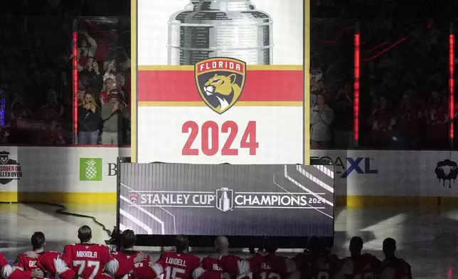 The Florida Panthers raise their Stanley Cup championship banner before the start of the NHL hockey game against the Boston Bruins, Tuesday, Oct. 8, 2024, in Sunrise, Fla. (AP Photo/Jim Rassol)