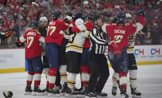 The Florida Panthers get into scrum with the Boston Bruins during the first period of an NHL hockey game, Tuesday, Oct. 8, 2024, in Sunrise, Fla. (AP Photo/Jim Rassol)