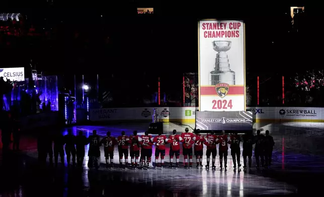 The Florida Panthers raise their Stanley Cup championship banner before the start of the NHL hockey game against the Boston Bruins, Tuesday, Oct. 8, 2024, in Sunrise, Fla. (AP Photo/Jim Rassol)