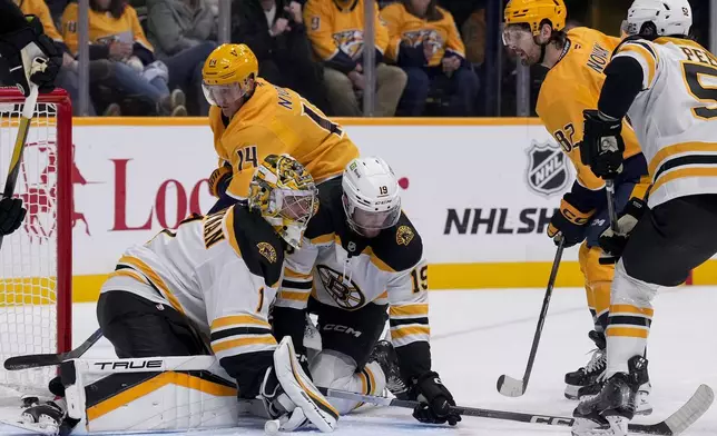 Nashville Predators center Tommy Novak (82) scores a goal past Boston Bruins goaltender Jeremy Swayman (1) and center John Beecher (19) during the second period of an NHL hockey game Tuesday, Oct. 22, 2024, in Nashville, Tenn. (AP Photo/George Walker IV)