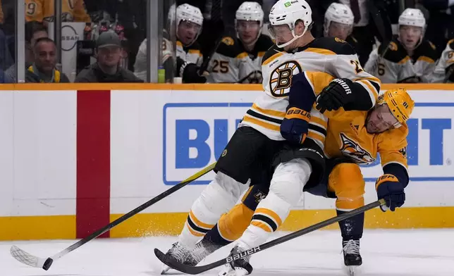 Boston Bruins defenseman Hampus Lindholm (27) and Nashville Predators center Jonathan Marchessault (81) vie for the puck during the second period of an NHL hockey game Tuesday, Oct. 22, 2024, in Nashville, Tenn. (AP Photo/George Walker IV)