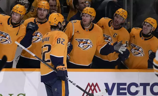 Nashville Predators center Tommy Novak (82) celebrates his goal with teammates during the second period of an NHL hockey game against the Boston Bruins, Tuesday, Oct. 22, 2024, in Nashville, Tenn. (AP Photo/George Walker IV)