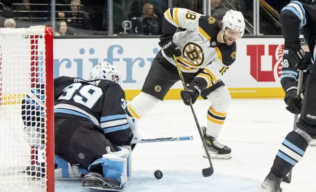 Utah Hockey Club goaltender Connor Ingram (39) makes a save as Boston Bruins center Pavel Zacha (18) shoots during the third period of an NHL hockey game, Saturday, Oct. 19, 2024, in Salt Lake City. (AP Photo/Spenser Heaps)