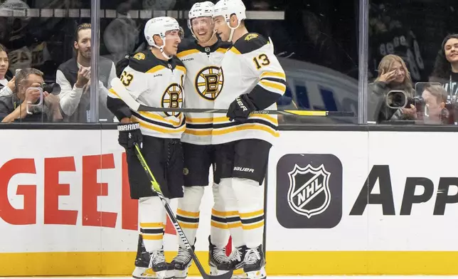 Boston Bruins left wings Brad Marchand and Cole Koepke and center Charlie Coyle, left to right, celebrate a goal during the second period of an NHL hockey game against the Utah Hockey Club, Saturday, Oct. 19, 2024, in Salt Lake City. (AP Photo/Spenser Heaps)