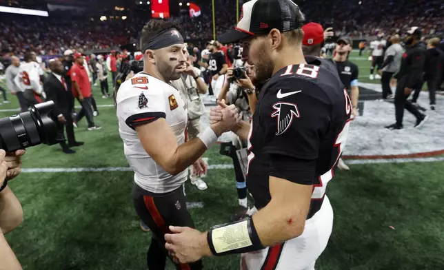 Atlanta Falcons quarterback Kirk Cousins (18) shakes hands with Tampa Bay Buccaneers quarterback Baker Mayfield after the Falcons defeated the Buccaneers during overtime in an NFL football game Friday, Oct. 4, 2024, in Atlanta. (AP Photo/Butch Dill)