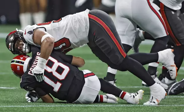 Tampa Bay Buccaneers defensive end Logan Hall (90) sacks Atlanta Falcons quarterback Kirk Cousins (18) during the first half of an NFL football game Thursday, Oct. 3, 2024, in Atlanta. (AP Photo/Butch Dill)