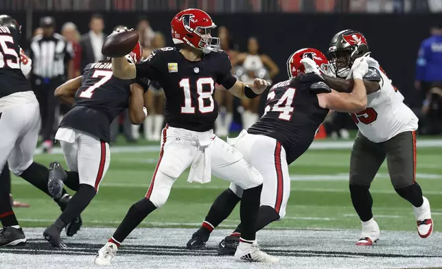 Atlanta Falcons quarterback Kirk Cousins (18) throws the game-wining touchdown pass to wide receiver KhaDarel Hodge (12) against the Tampa Bay Buccaneers during overtime in an NFL football game Thursday, Oct. 3, 2024, in Atlanta. (AP Photo/Butch Dill)