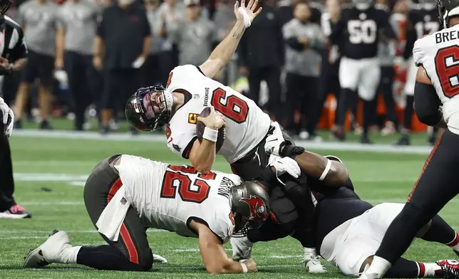 Tampa Bay Buccaneers quarterback Baker Mayfield (6) reacts as he is sacked by Atlanta Falcons defensive tackle David Onyemata (90) during the second half of an NFL football game Thursday, Oct. 3, 2024, in Atlanta. (AP Photo/Butch Dill)