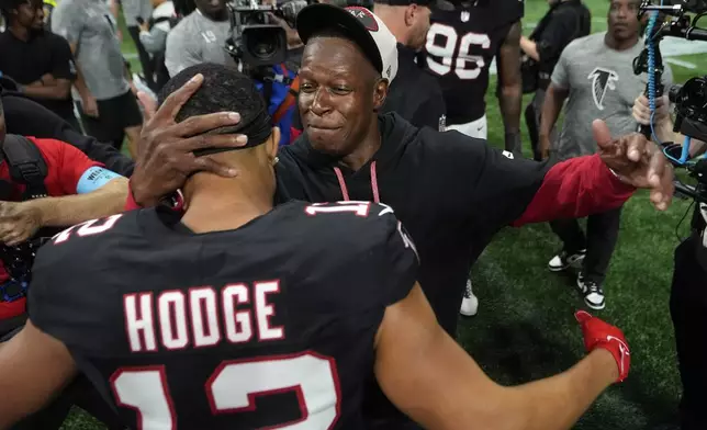 Atlanta Falcons head coach Raheem Morris celebrates with wide receiver KhaDarel Hodge (12) after scoring against the Tampa Bay Buccaneers during overtime in an NFL football game Thursday, Oct. 3, 2024, in Atlanta. (AP Photo/John Bazemore)