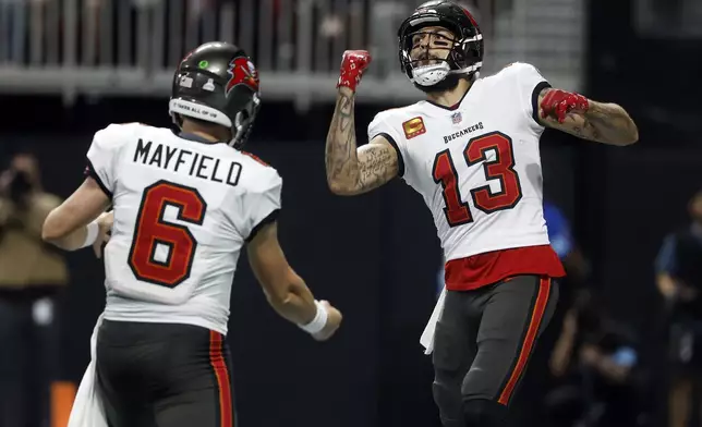 Tampa Bay Buccaneers wide receiver Mike Evans (13) celebrates with quarterback Baker Mayfield (6) after scoring against the Atlanta Falcons during the first half of an NFL football game Thursday, Oct. 3, 2024, in Atlanta. (AP Photo/Butch Dill)