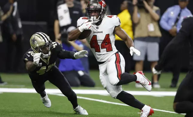 Tampa Bay Buccaneers running back Sean Tucker (44) runs toward the end zone to score past New Orleans Saints safety J.T. Gray (48) during the first half of an NFL football game in New Orleans, Sunday, Oct. 13, 2024. (AP Photo/Butch Dill)