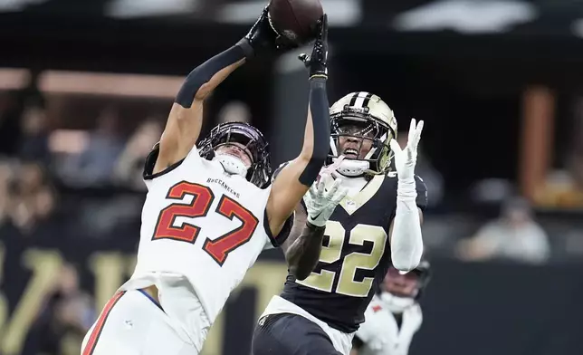 Tampa Bay Buccaneers cornerback Zyon McCollum (27) intercepts a pass intended for New Orleans Saints wide receiver Rashid Shaheed (22) during the second half of an NFL football game in New Orleans, Sunday, Oct. 13, 2024. (AP Photo/Michael Conroy)