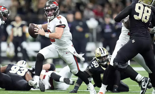 Tampa Bay Buccaneers quarterback Baker Mayfield, middle left, runs against the New Orleans Saints during the first half of an NFL football game in New Orleans, Sunday, Oct. 13, 2024. (AP Photo/Michael Conroy)