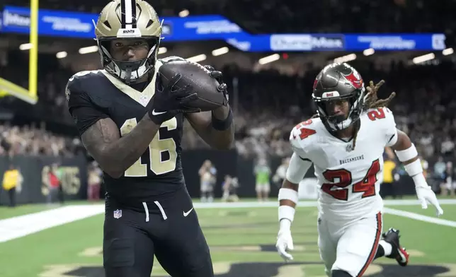 New Orleans Saints wide receiver Bub Means (16) catches a touchdown pass in front of Tampa Bay Buccaneers cornerback Tyrek Funderburk (24) during the first half of an NFL football game in New Orleans, Sunday, Oct. 13, 2024. (AP Photo/Michael Conroy)