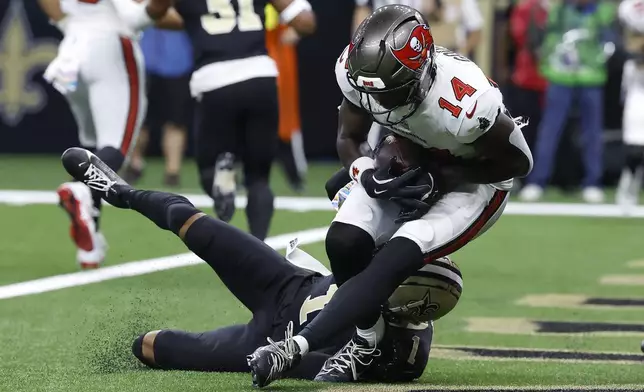 Tampa Bay Buccaneers wide receiver Chris Godwin (14) catches a touchdown pass against New Orleans Saints cornerback Alontae Taylor during the first half of an NFL football game in New Orleans, Sunday, Oct. 13, 2024. (AP Photo/Butch Dill)