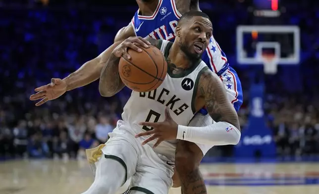 Milwaukee Bucks' Damian Lillard, front, gets past Philadelphia 76ers' KJ Martin during the first half of an NBA basketball game, Wednesday, Oct. 23, 2024, in Philadelphia. (AP Photo/Matt Slocum)