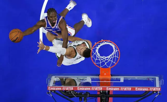 Philadelphia 76ers' Tyrese Maxey, left, goes up for a shot against Milwaukee Bucks' Brook Lopez during the first half of an NBA basketball game, Wednesday, Oct. 23, 2024, in Philadelphia. (AP Photo/Matt Slocum)