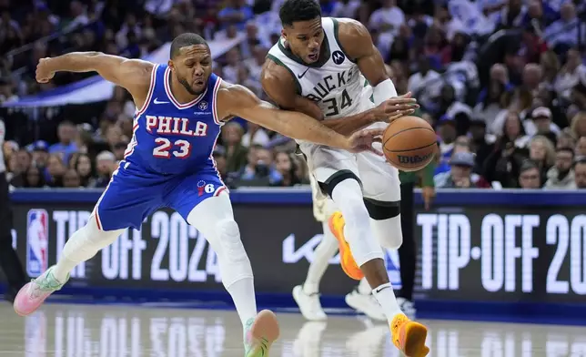 Milwaukee Bucks' Giannis Antetokounmpo, right, tries to get past Philadelphia 76ers' Eric Gordon during the first half of an NBA basketball game, Wednesday, Oct. 23, 2024, in Philadelphia. (AP Photo/Matt Slocum)