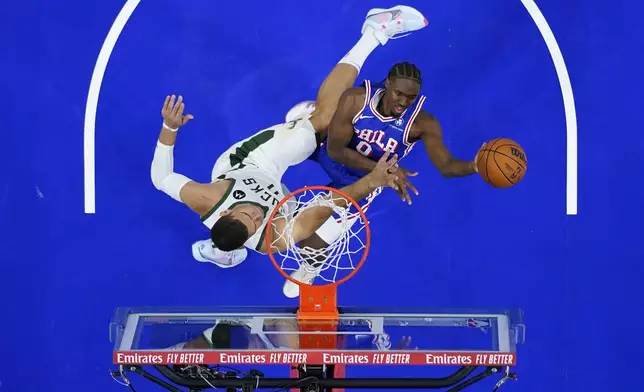 Philadelphia 76ers' Tyrese Maxey, right, goes up for a shot against Milwaukee Bucks' Brook Lopez during the first half of an NBA basketball game, Wednesday, Oct. 23, 2024, in Philadelphia. (AP Photo/Matt Slocum)