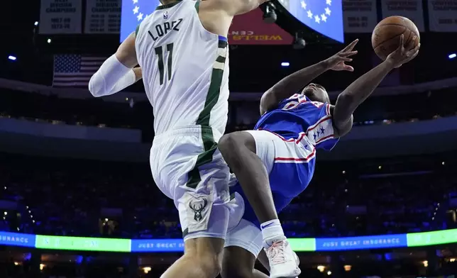 Philadelphia 76ers' Tyrese Maxey, right, goes up for a shot against Milwaukee Bucks' Brook Lopez during the first half of an NBA basketball game, Wednesday, Oct. 23, 2024, in Philadelphia. (AP Photo/Matt Slocum)