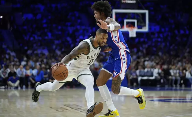 Milwaukee Bucks' Damian Lillard, left, tries to get past Philadelphia 76ers' Kelly Oubre Jr. during the first half of an NBA basketball game, Wednesday, Oct. 23, 2024, in Philadelphia. (AP Photo/Matt Slocum)