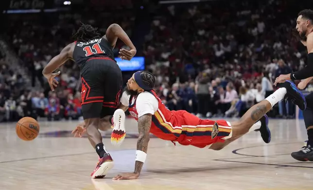 New Orleans Pelicans forward Brandon Ingram dives for a loose ball against Chicago Bulls guard Ayo Dosunmu (11) in the first half of an NBA basketball game in New Orleans, Wednesday, Oct. 23, 2024. (AP Photo/Gerald Herbert)