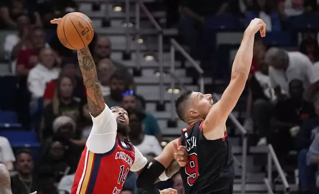 New Orleans Pelicans forward Brandon Ingram (14) pulls down the ball against Chicago Bulls center Nikola Vucevic (9) in the first half of an NBA basketball game in New Orleans, Wednesday, Oct. 23, 2024. (AP Photo/Gerald Herbert)