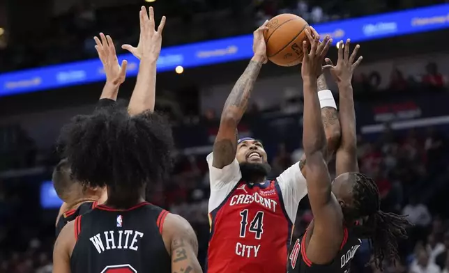 New Orleans Pelicans forward Brandon Ingram (14) goes to the basket against Chicago Bulls guard Ayo Dosunmu in the first half of an NBA basketball game in New Orleans, Wednesday, Oct. 23, 2024. (AP Photo/Gerald Herbert)