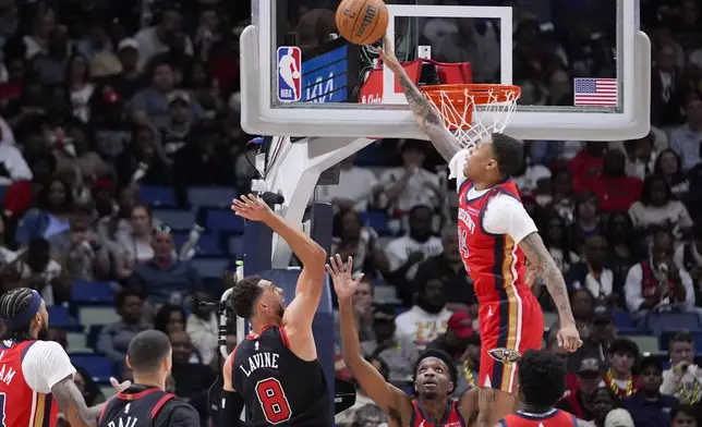 New Orleans Pelicans guard Jordan Hawkins (24) blocks a shot by Chicago Bulls guard Zach LaVine (8) in the first half of an NBA basketball game in New Orleans, Wednesday, Oct. 23, 2024. (AP Photo/Gerald Herbert)