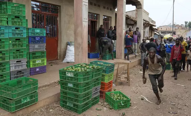 A man runs to load a crate of avocados inside a truck in Kayanza province, Burundi, Sept. 18, 2024. (AP Photo/Brian Inganga)