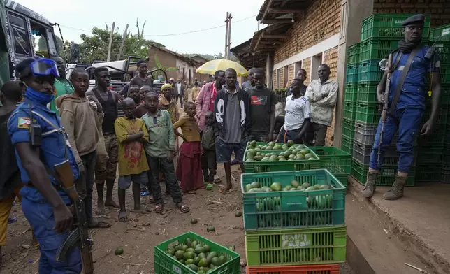 Burundian police officers stand beside crates of avocados in Kayanza province, Burundi, Sept. 18, 2024. (AP Photo/Brian Inganga)