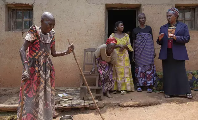 Prudencienne Namukobwa, 85, left, entertains her guests with akazehe, a Burundian traditional form of musical greeting performed exclusively by women, outside her house in Ngozi, Burundi, Friday, Sept. 20, 2024. (AP Photo/Brian Inganga)