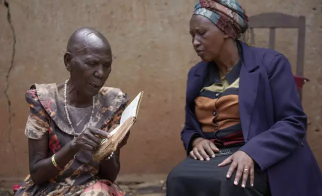 Emelyne Nzeyimana, right, and Prudencienne Namukobwa, read the Bible at her home in Ngozi, Burundi, Friday, Sept. 20, 2024. (AP Photo/Brian Inganga)