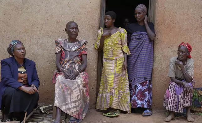 Prudencienne Namukobwa, 85, second left, sits with her guests outside her house in Ngozi, Burundi, Friday, Sept. 20, 2024. (AP Photo/Brian Inganga)