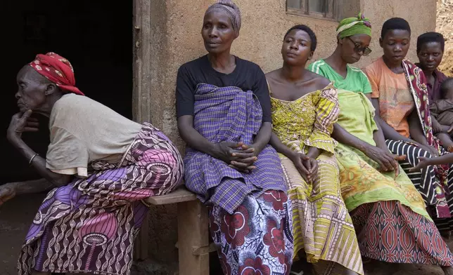 Women listen to Prudencienne Namukobwa, not pictured, as she performs akazehe, a Burundian traditional form of musical greeting performed exclusively by women, outside her house in Ngozi, Burundi, Friday, Sept. 20, 2024. (AP Photo/Brian Inganga)