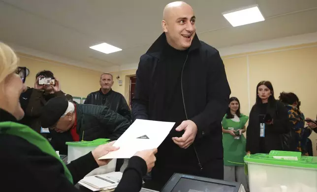 CORRECTS THE NAME OF POLITICAL COALITION - Nika Melia, a leader of Coalition for Changes, receives his ballot at a polling station during the parliamentary election in Tbilisi, Georgia, Saturday, Oct. 26, 2024. (AP Photo/Zurab Tsertsvadze)